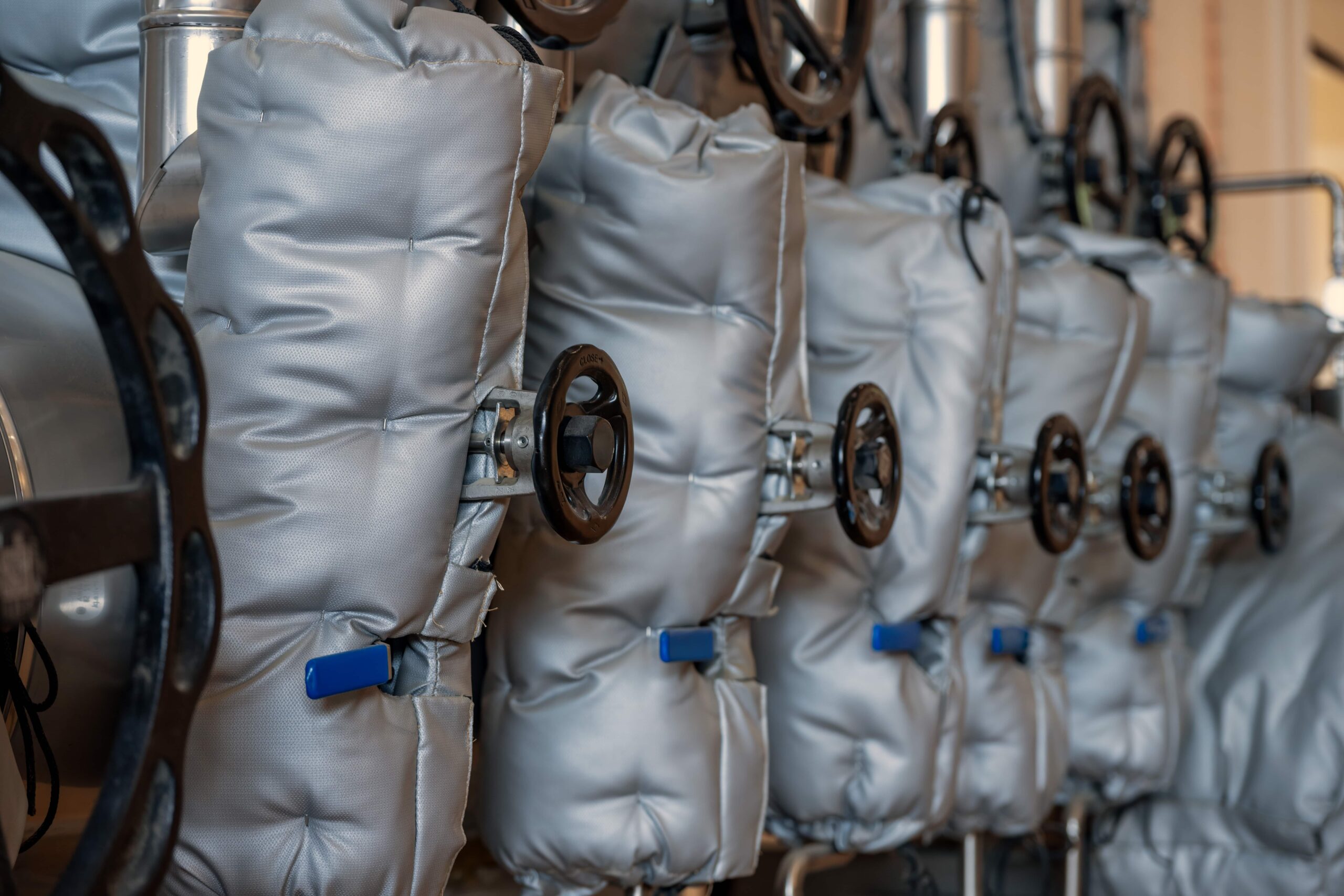 A hang-lined selection of white thermal insulation covers for industrial use.