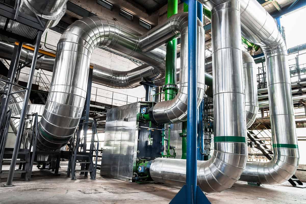An industrial scene filled with various pipes, emphasizing insulation services within an industrial environment.